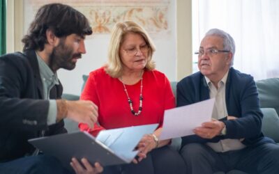 Groupe de trois personnes examinant des papiers lors d'une réunion informelle