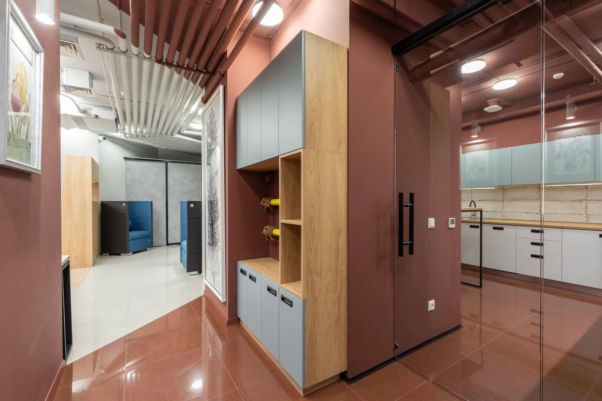 Espace de travail moderne avec cuisinette intégrée, mobilier design et cloisons vitrées